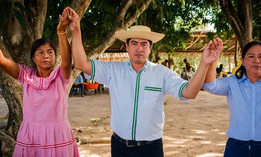 Comunarios celebran tomados de las manos durante una actividad en la comunidad